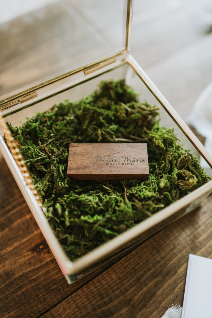 Custom wood USB as photo storage in a glass box with moss