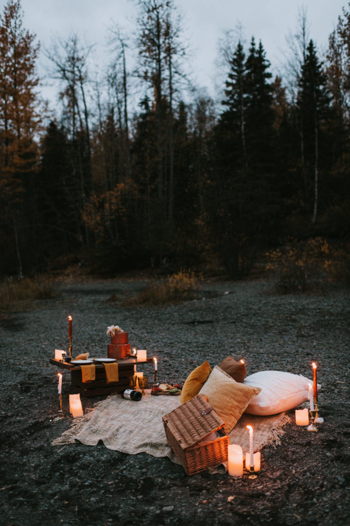 Full elopement picnic scene with candles, pillows, snacks, drinks and dessert