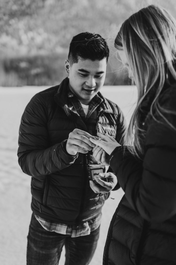 man putting a ring on his girlfriends photo after a proposal