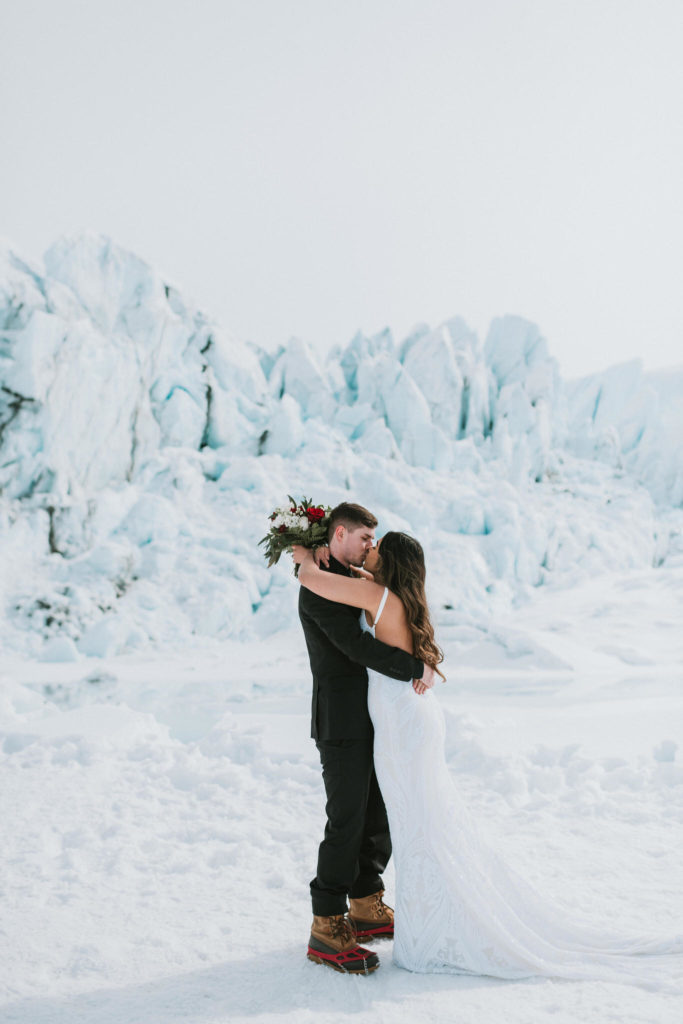 couple kissing on glacier after proposal