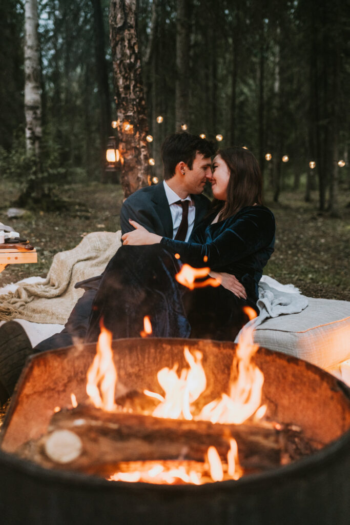 couple snuggling by a campfire on their elopement day